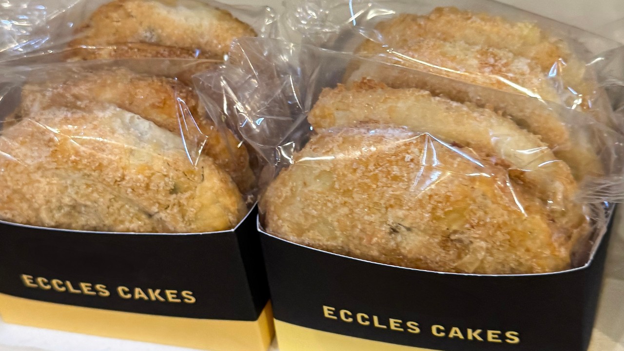 Selection of traditional English Eccles cakes, also known as squashed fly cakes. Baked to golden perfection in flaky puff pastry, these sweet turnovers are filled with juicy dried currants.